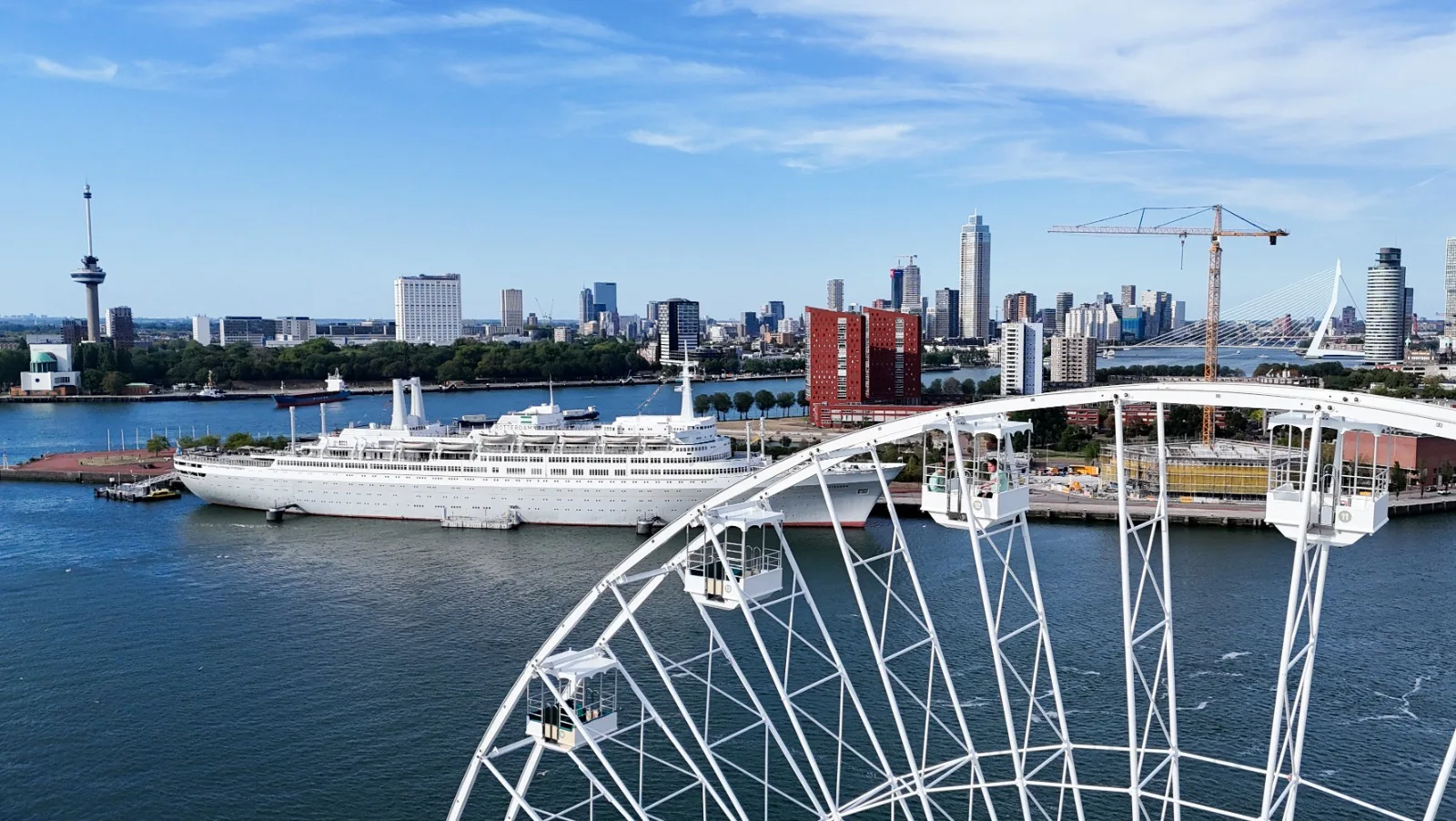Gondels van de Beelen Eye met de SS Rotterdam en de skyline van Rotterdam op de achtergrond
